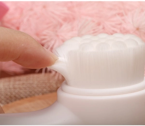 Vista macro delle setole morbide in silicone bianco della spazzola manuale viso