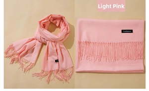 Detail of light pink cashmere shawl scarf showing soft texture and fringe tassels
