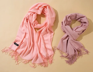 Detail of pink and purple cashmere scarves with long fringes and woven texture