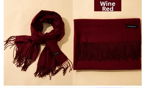 Detail showing wine red cashmere scarf texture with tassels and neat folding effect