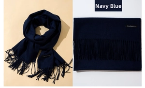 Detail of navy blue cashmere scarf featuring soft fringe ends and premium textile texture