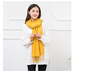 Detail showing bright yellow scarf texture with soft fringes for autumn winter style