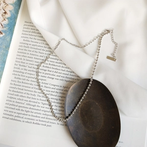 Detail of 925 sterling silver asymmetrical beaded choker chain on vintage background