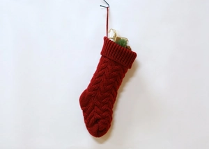 Detailed close-up of dark red cable knit Christmas stocking with hanging loop