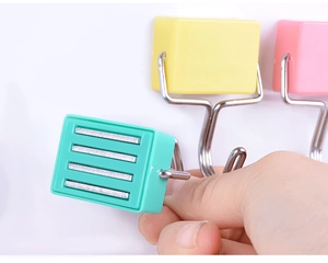 Detail of colorful magnetic hooks showing strong strip magnets on the base for fridge