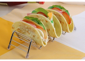 Detail of 4-slot stainless steel taco holder with anti-slip feet on a checkered mat