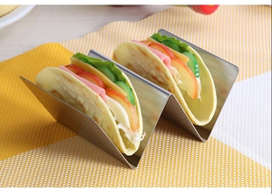 Detail of wave-shaped stainless steel taco holder for two tacos on a checkered placemat