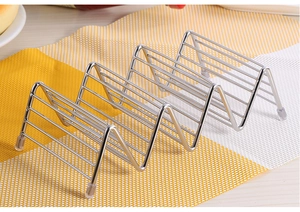 Top view of a stainless steel taco holder with four anti-slip feet on a placemat