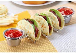 Stainless steel taco holder with four slots and two dipping sauce cups on table mat