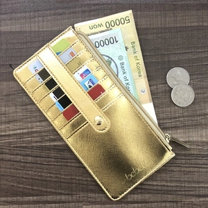 Detail view of gold long wallet interior with card slots, zipper pocket and bank notes