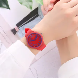 Close-up of a red silicone jelly watch with blue numerals on a person's wrist