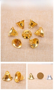 Macro detail of 2.1cm gold and silver Christmas bells compared with a coin size