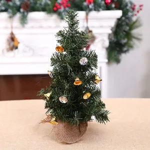Mini green Christmas tree with gold bells and a burlap base for holiday tabletop decor