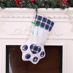 Christmas stocking in dog paw shape with blue plaid trim and fish charms on fireplace