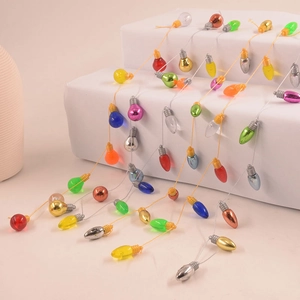 Colorful mini bulb holiday ornaments with metallic finish on white stone pedestals