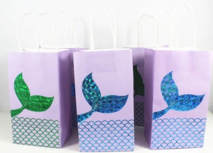 Detail of mermaid scale paper gift bags with holographic gold foil and white rope handles