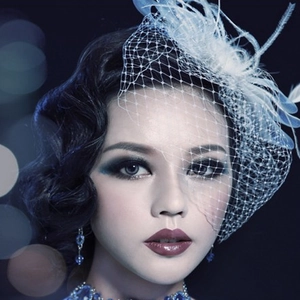 Detail of vintage 1920s headpiece with blue feathers, mesh veil and sparkling rhinestones