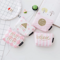 Flat lay of pink and white canvas coin purses with stripes and polka dots on a desk