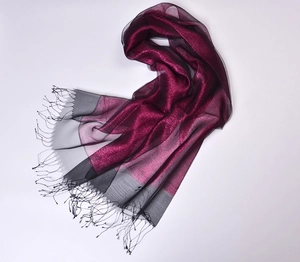 Detail of silk organza scarf with deep red and black dual tones and gold tassel fringe