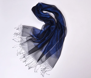 Close-up of luxury silk organza scarf with shimmering gold thread and fine tassel edges