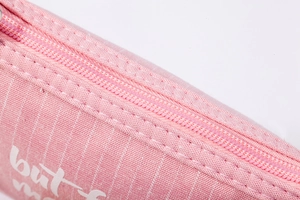 Close-up of pink canvas pouch showing fine fabric texture, zipper and white lettering