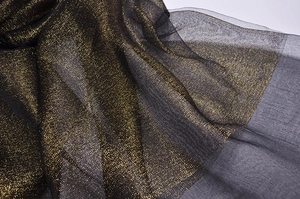 Detailed macro shot of black silk organza fabric featuring shimmering gold lurex threads