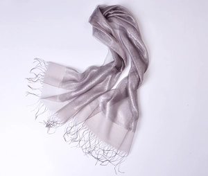Close-up of silver silk organza scarf featuring shimmering texture and fringe details
