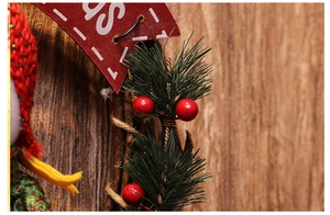 Detailed macro view of Christmas wreath featuring red berries, pine needles and wood sign