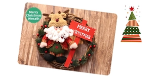 Detail of Christmas wreath with Santa doll, red Merry Christmas sign, and pine needle decor