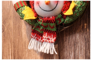 Close-up of a Christmas snowman wreath featuring red-green knit scarf and star details