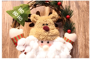 Detail of Christmas wreath with plush Santa, reindeer, pine needles and red berries