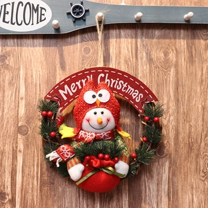 Festive Merry Christmas wreath with snowman doll, pine needles and red berries on wood wall