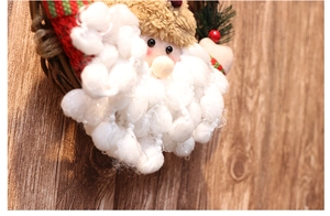 Close-up of plush Santa Claus on a woven Christmas wreath with soft fabric details