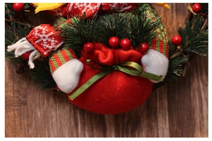 Detail shot of Christmas wreath featuring a plush doll in red and green knitwear
