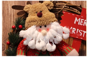 Detailed close-up of Santa Claus plush doll with knit hat and pine needles decoration