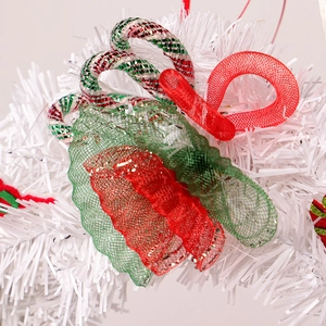 Christmas wreath with white tinsel, festive plaid bows and candy cane ornaments