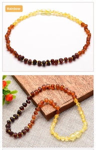 Macro shot of natural Baltic amber beads in a rainbow gradient on a wooden and linen base