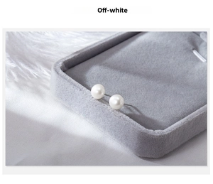 Close-up of natural creamy white freshwater pearl stud earrings on gray velvet jewelry box