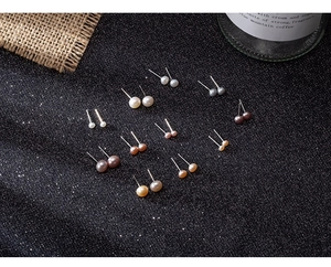 Macro display of diverse natural freshwater pearl studs in white, pink, and grey shades
