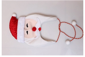 Detail of red Santa hat with plush white trim, face embroidery and decorative gold braids