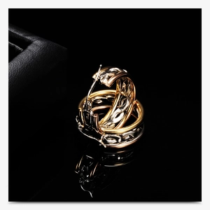 Three-color twisted hoop earrings in gold silver and rose gold finishes on black case