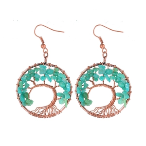 Detailed close-up of handmade Tree of Life earrings with copper wire and turquoise stones