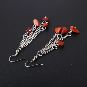 Detail of silver chain tassel earrings with bohemian red natural crystal stones