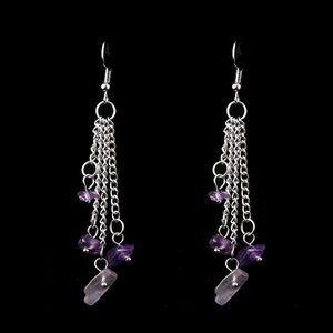 Detail of bohemian long tassel earrings with purple natural crystal and silver chains