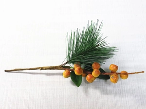 Detail view of artificial orange berry branches with green pine needles for DIY home decor