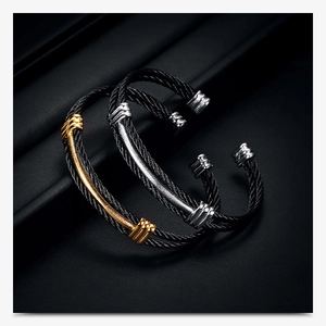 Detail of twisted cable metal bracelets with contrasting black and gold plating finish