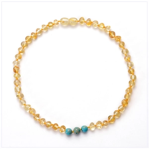 Détail du collier d'ambre pour bébé avec perles turquoise et fermoir à visser sûr