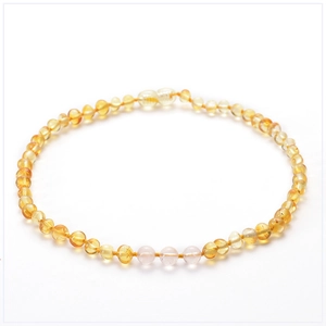 Détail du collier pour enfants en perles d'ambre et quartz rose au fini poli brillant