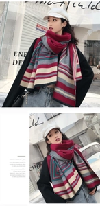 Detail of colorful striped winter scarf with soft fringes worn with a black coat