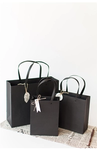 Three sizes of black paper gift bags with ribbon handles and Especially for you tags
